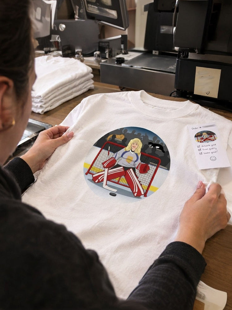 A team member checking a freshly printed shirt