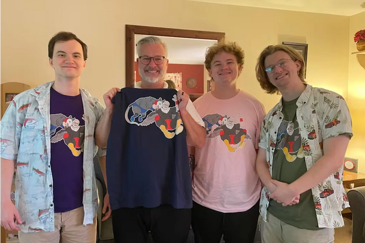 A dad and his three sons all wearing the same hand-drawn possum wrestling design